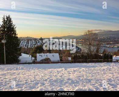 Blick nach Westen von Burnaby auf die Innenstadt von Vancouver, den Burrard Inlet und die North Shore Mountains an einem Wintertag mit Schnee. Stockfoto