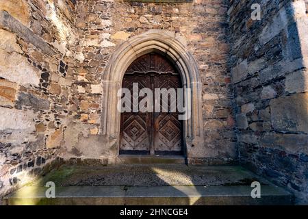 Alte Holztür. Alte raue und zerkratzte Holztür in der Kirche. Stockfoto