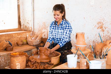 Weibliche Gießkrug auf Töpferscheibe Stockfoto