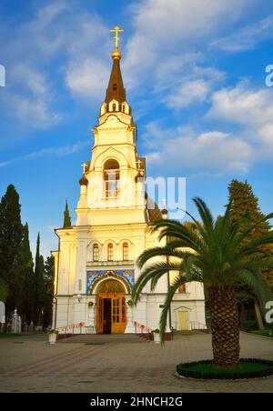 Sotschi, Russland, 11.01.2021. Kathedrale des Erzengels Michael unter grünen Palmen unter einem blauen Himmel Stockfoto