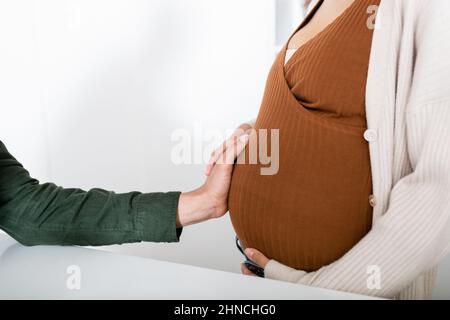 Beschnittene Ansicht des afroamerikanischen Mannes, der den Bauch einer Schwangeren berührt Stockfoto