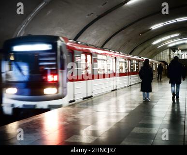 Verschwommenes Bild von Passagieren, die auf dem Bahnsteig stehen und auf den Zug warten. Stockfoto