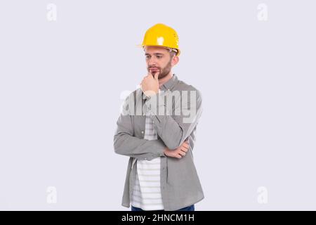 Bauarbeiter Im Stehen Denken. Architekt, Der Arbeit Analysiert. Mann, der isoliert in einem harten Helm steht Stockfoto