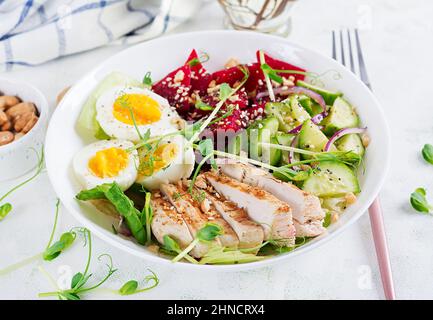 Gesundes Frühstück. Gekochter Eiersalat mit Gemüse, Gurken, Rote Beete und gegrilltem Hähnchenfilet und roten Zwiebeln. Mittagessen. Stockfoto