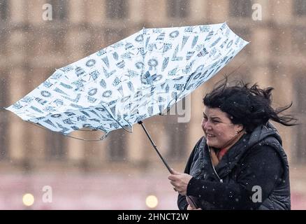 Frauen kämpfen bei nassem und windigem Wetter im Zentrum Londons mit Regenschirmen Stockfoto