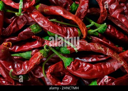 Gefrorener getrockneter Chilli auf einem schwarzen strukturierten Hintergrund Stockfoto