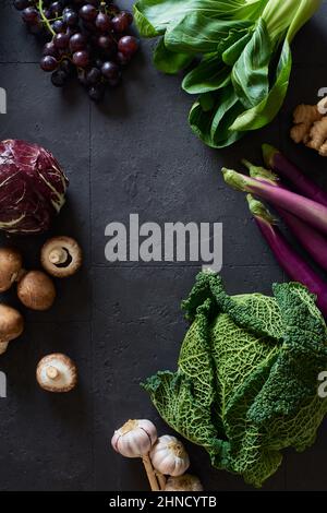 Von oben Stillleben mit frischem Obst und Gemüse auf dunklem Hintergrund Stockfoto