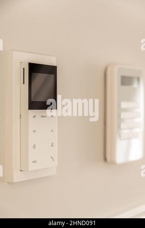 Modernes Video-Türtelefon, das an der weißen Wand hängt, für die Fernbedienung, um Zugang zum Haus zu ermöglichen Stockfoto