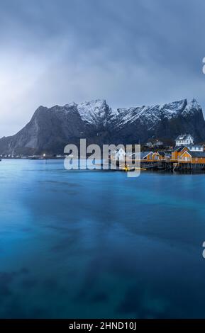 Herrlicher Blick auf eine kleine Siedlung mit Wohnhäusern in der Bucht des Meeres in der Nähe der Bergküste auf den Lofoten-Inseln in Norwegen Stockfoto