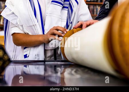 Aliyah zu torah. Mann im Tempel Feier der Bar Mizwa Mann liest im Buch Tora. Das Tfilin liegt auf seinen Händen. Synagoge, auch A genannt Stockfoto