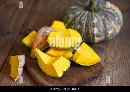 Grünes Kürbisfutter auf Holz-Schneidebrett-Hintergrund, frischer asiatischer Thai-Kürbis frome den Garten für gekochtes Essen oder Dessert, gehackter Kürbis Stockfoto