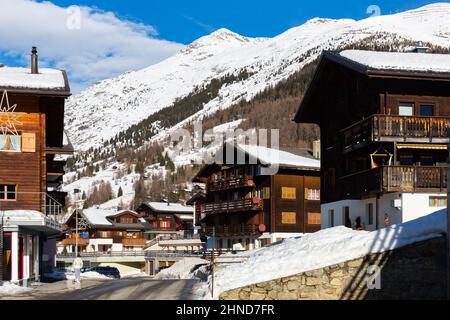 Straßenansicht von Bellwald auf dem Hintergrund der verschneiten Alpen am Wintertag Stockfoto