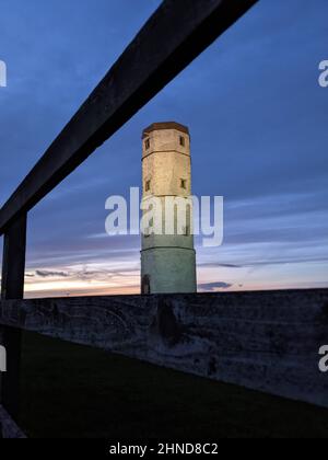 Der alte Leuchtturm in Flamborough Head, North Yorkshire, wird durch den neuen Lichtstrahl des Leuchtturms beleuchtet Stockfoto