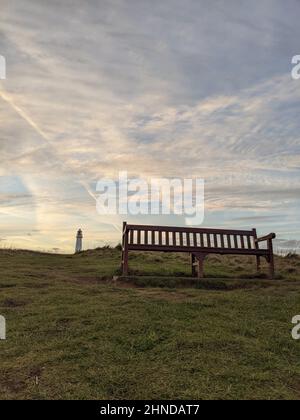 Eine Holzbank gegen einen wunderschönen Sonnenuntergang Himmel Stockfoto