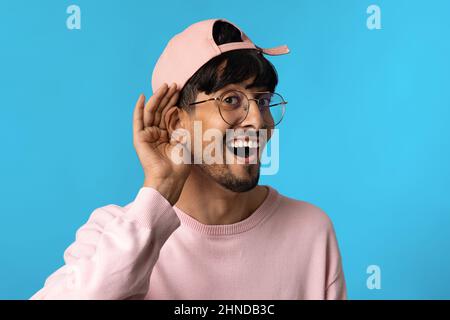 Neugieriger inder, der die Hand am Ohr hält Stockfoto