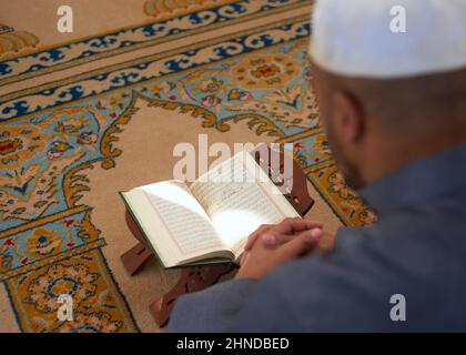 Ansicht von oben eines muslimischen Mannes, der den Koran liest Stockfoto
