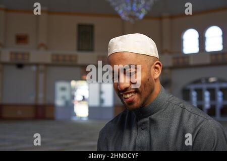 Ein junger muslimischer Mann lächelt in einer Moschee Stockfoto