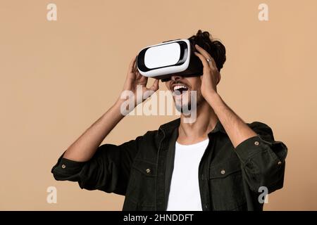 Erstaunter junger bärtiger Mann mit Virtual-Reality-Brille Erfahrung, Nahaufnahme Stockfoto