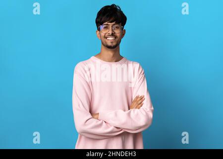 Hübscher junger Mann aus dem Nahen Osten, der auf Blau posiert Stockfoto