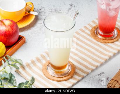 Frisch vereister Apple Happy Pi mit einem Glas Fruchtsaft auf grauem Hintergrund. Konzept für gesunde Getränke Stockfoto