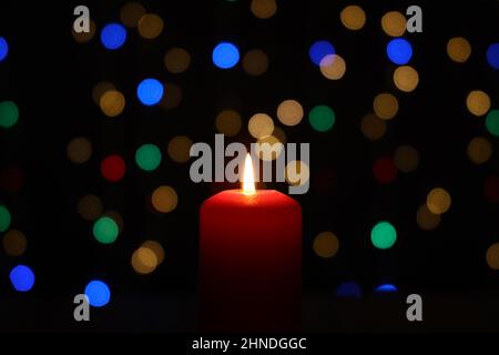 Brennende Kerze mit einem schönen Bokeh im Hintergrund Stockfoto