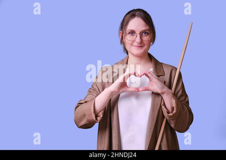 Frau Lehrerin mit herzförmigen Fingern Geste auf Studio blauen Hintergrund, kopieren Raum Stockfoto