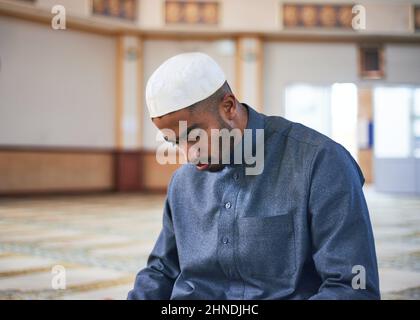 Ein Muslim beugt sich im Gebet und kniet in einer Moschee Stockfoto