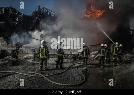 Dana, Syrien. 16th. Februar 2022. Mitglieder der syrischen Zivilverteidigung, bekannt als Weißhelme, lösten ein Feuer aus, das infolge eines Raketenangriffs des syrischen Regimes und russischer Truppen auf das Dorf Tarminin in in der Nähe der Stadt Dana in einem Treibstofflager ausbrach. Nach Angaben der Weißhelme wurden bei einem Artilleriebeschuss auf einem Brennstoffmarkt, der angeblich einer dschihadistischen Gruppe angehört, vier Zivilisten getötet und zwei weitere verletzt. Quelle: Anas Alkharboutli/dpa/Alamy Live News Stockfoto