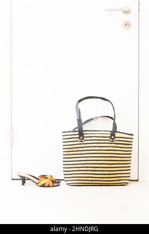 Sommer-Trendschuhe und eine Strandtasche werden vor der Tür zubereitet. Stockfoto
