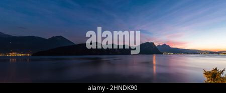 Großes Nachtpanorama des Vierwaldstättersees. Berge am Abend Sonnenuntergang. Im Hintergrund die Lichter der Stadt Luzern. Stockfoto