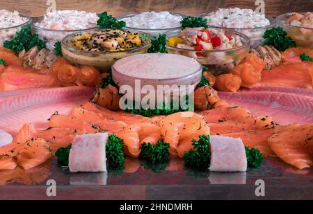 Anordnung von verschiedenen Fisch-Gourmet-Speisen, schön auf einer Stahlplatte angeordnet Stockfoto