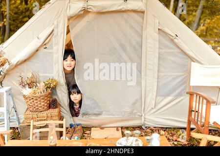 Japanischer Bruder Und Schwester Peeking Aus Ihrem Zelt Stockfoto