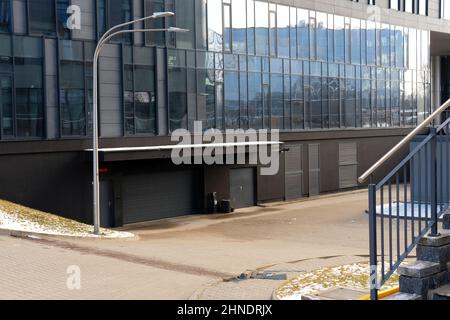 Außenansicht eines modernen Bürogebäudes mit Glaswänden und Garagentor Stockfoto