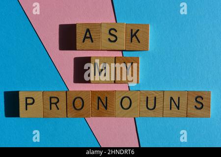 Ask My Pronomen, Wörter in Holzalphabet Buchstaben isoliert auf rosa und blauen Hintergrund Stockfoto