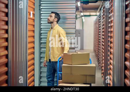 Konzentrierter Mitarbeiter, der im Lager nach bestellten Artikeln sucht Stockfoto