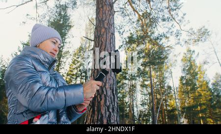 Frau, die auf einem Handheld-Film hält 3-Achsen-Gimbal-Stabilisiergerät im Winter für Smartphone. Girl Blogger Make Selfie, Broadcast Video Blogging, Vlogging. Videograf Operator Nimmt Fotovideo Auf. Stockfoto