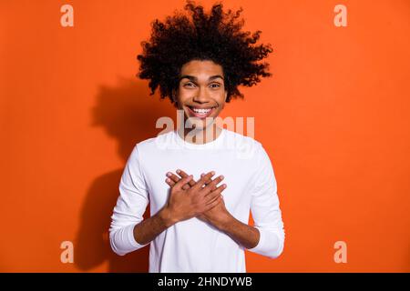 Foto von charmanten beeindruckt Kerl gekleidet weißen Hemd Arme Brust isoliert orange Farbe Hintergrund Stockfoto