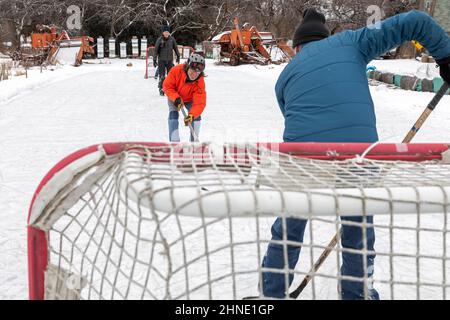 Detroit, Michigan - Ältere Männer spielen Eishockey auf einer behelfsmäßigen Hinterhof-Eisbahn. Stockfoto