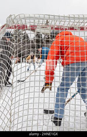 Detroit, Michigan - Ältere Männer spielen Eishockey auf einer behelfsmäßigen Hinterhof-Eisbahn. Stockfoto