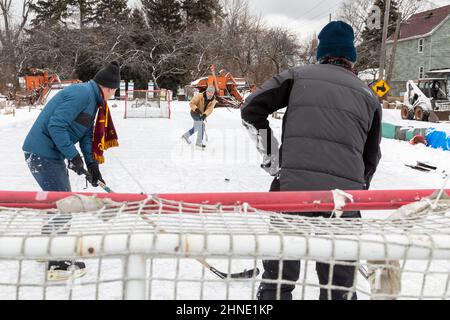 Detroit, Michigan - Ältere Männer spielen Eishockey auf einer behelfsmäßigen Hinterhof-Eisbahn. Stockfoto