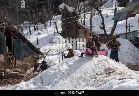 Baramulla, Indien. 16th. Februar 2022. Die Kinder nehmen an einem sonnigen Tag in Drang an einer Schlittenfahrt auf einer schneebedeckten Piste Teil. (Foto von Idrees Abbas/SOPA Images/Sipa USA) Quelle: SIPA USA/Alamy Live News Stockfoto