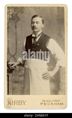 Original viktorianische Carte de Visite (CDV) oder Visitenkarte eines orientalischen Mannes mit Schürze, Flügelspitzenkragen, schmalen Revers an der Weste, Essstäbchen in der Tasche, möglicherweise ein Kellner oder Restaurantbesitzer aus Kirby's Studio 66 Hill Street, Peckham, London, Großbritannien, ca. Ende 1880s, 1890 Stockfoto