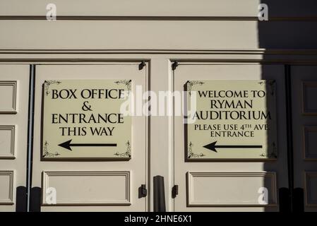 Weiße Schilder mit schwarzen Schriftzügen und Pfeilen begrüßen Besucher des Ryman Auditorium in Nashville, Tennessee, und zeigen auf die Kasse und den Eingang. Stockfoto