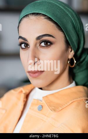 Nahaufnahme des Porträts einer jungen muslimischen Frau mit Kopftuch und goldenem Ohrring Stockfoto