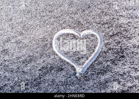 Schwarzer Ruß aus dem Kesselraum auf weißem Schnee. Natürlicher Hintergrund. Schnee gemischt mit Kohleroß, schlechte Ökologie. Umweltverschmutzung. Ein Herz ist schmerzhaft Stockfoto