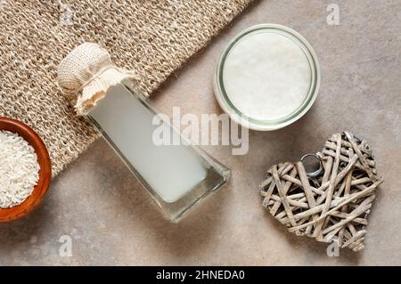 Fermentiertes Reiswasser und verschiedene Zutaten und Komponenten für Wellness- und Verjüngungskuren. Nahaufnahme, Draufsicht, Platz für Text, Nachbau Stockfoto