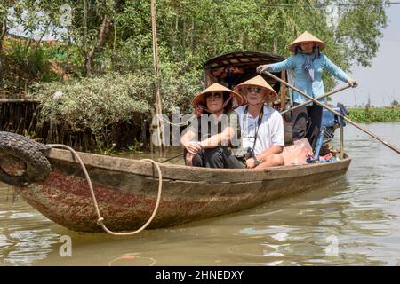 Vietnamesin rudert Touristen entlang des Mekong Flusses in einem traditionellen Holzboot (Sampan), Mekong Delta, Vinh Long Provinz, Südvietnam, Sou Stockfoto