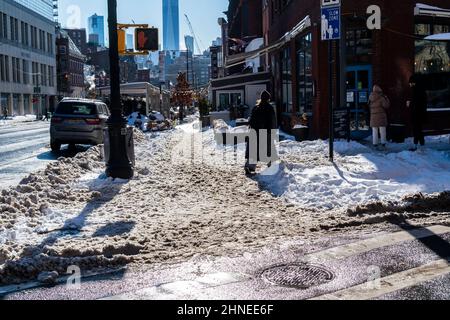 Fußgänger manövrieren am Sonntag, dem 30. Januar 2022, durch ungeklärte Bürgersteige in Greenwich Village in New York, nachdem ein Nor-Easter 8 Zoll in der Stadt abgeladen und kaltes Wetter den Schnee eingefroren hatte. (© Richard B. Levine) Stockfoto