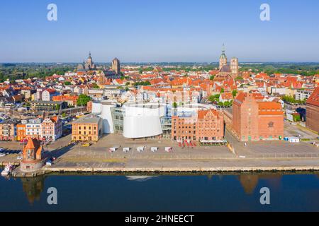 Luftaufnahme über die Uferpromenade und das öffentliche Aquarium Ozeaneum im Hafen der Hansestadt Stralsund im Sommer, Mecklenburg-Vorpommern, Deutschland Stockfoto