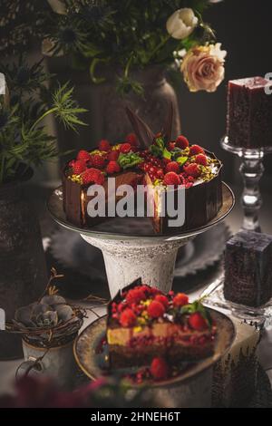 Leckere Mousse-Torte mit geschmolzener Schokolade, verziert mit Himbeeren Stockfoto